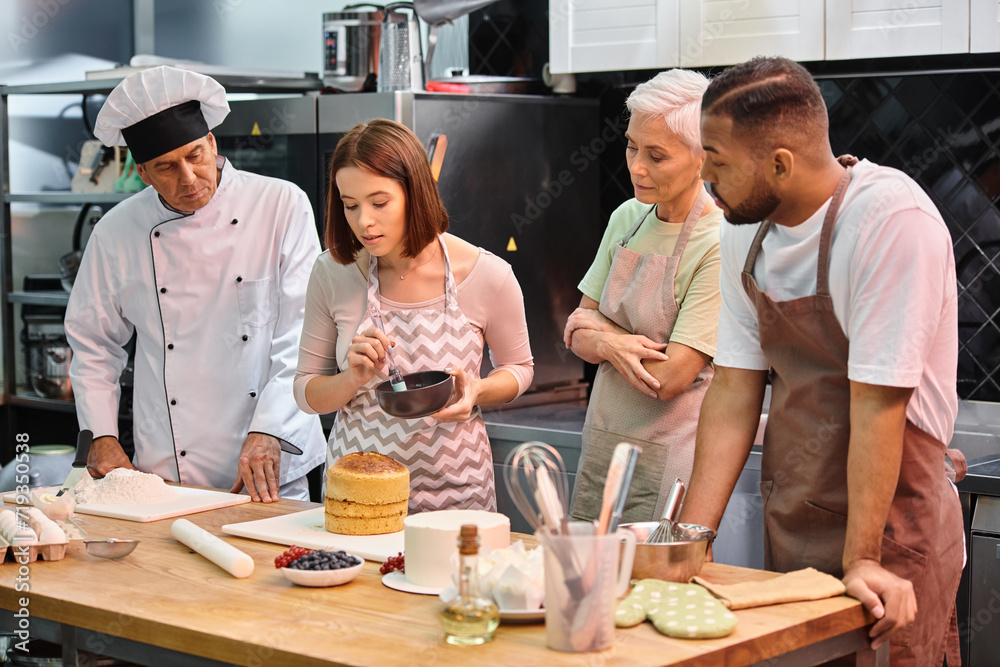 young attractive woman learning how to use silicone brush next to her diverse friends and chef young attractive woman learning how to use silicone brush next to her diverse friends and chef