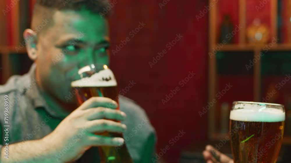 Pints Cheering Side closeup of Biracial man cheering with pint of beer with ...