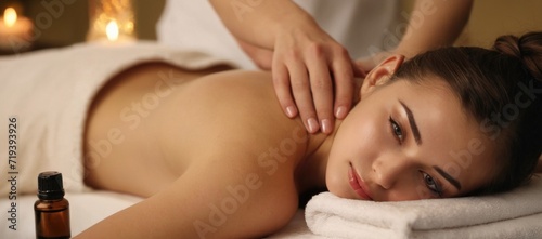 girl is lying on the massage table and enjoying an essential oil massage. The masseur s hand gently presses the girl s waist. The essential oil flows on the girl s skin