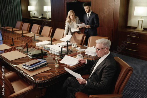 Fotografie Group of biracial attorneys doing paperwork side by side in classic spacious off