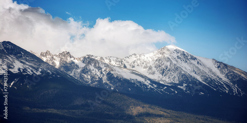 nature background of mighty high tatra ridge in spring at high noon. snow capped rocky peaks of slovakia beneath a cloudy sky © Pellinni