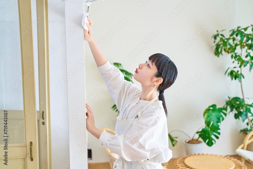 部屋を拭き掃除する若い女性 部屋を拭き掃除する若い女性