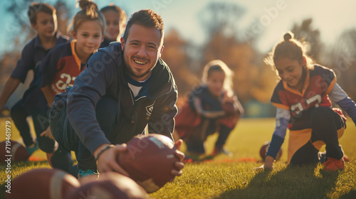 Elementary school coach playing American football with his students photo