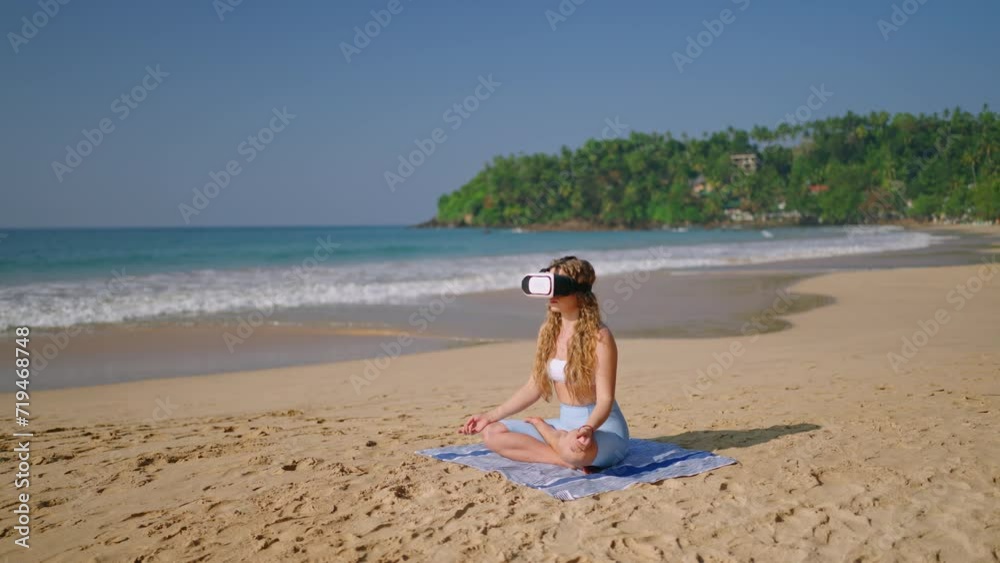 Woman uses VR headset for meditation on serene beach, finds solace in virtual retreat. Concept of tranquility in metaverse, perfect escape while sitting on sand, lotus pose, digital solitude practice. Woman uses VR headset for meditation on serene beach, finds solace in virtual retreat. Concept of tranquility in metaverse, perfect escape while sitting on sand, lotus pose, digital solitude practice.