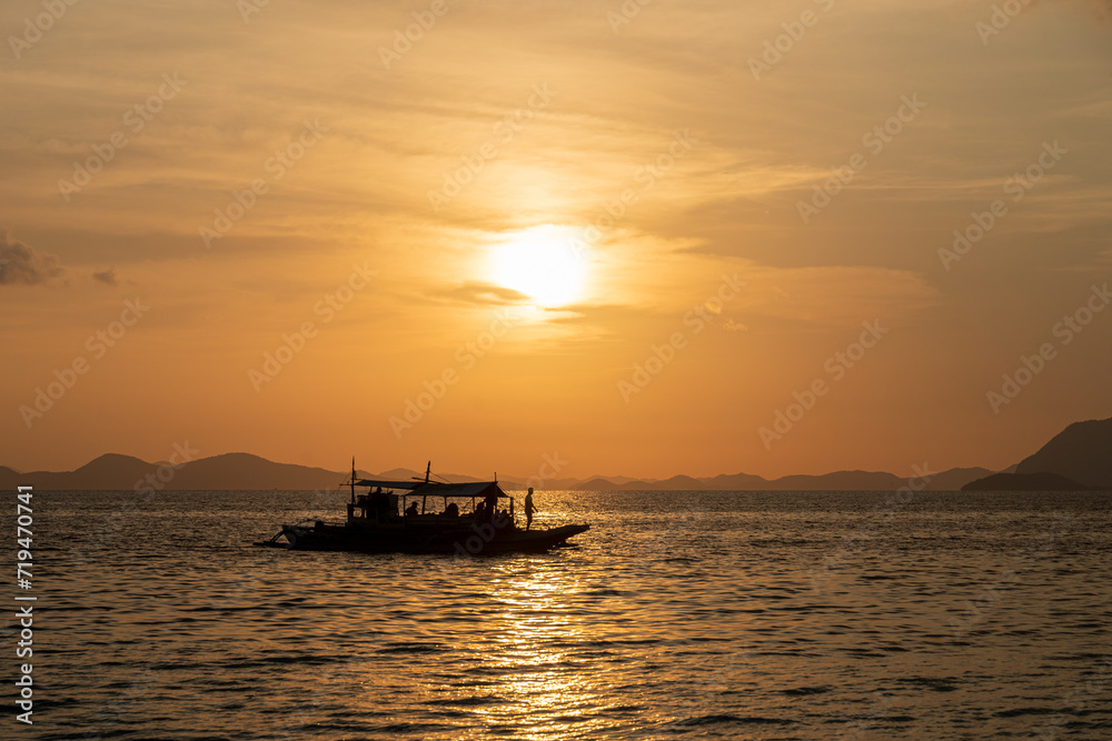 Bateau de pêche à contre jour avec coucher de soleil