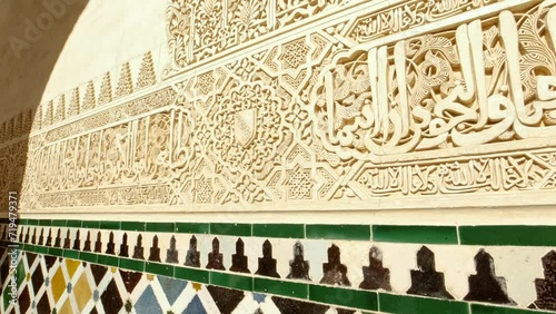 The Alhambra Palace - Tile baseboards and cursive engraved arabesques in the Court of the Myrtles Nasrid Palace in Granada, Anadalucia, Spain photo