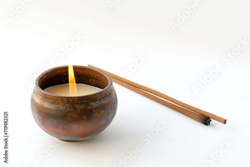 A candle and chopsticks placed on a white surface. Versatile image suitable for various themes and concepts