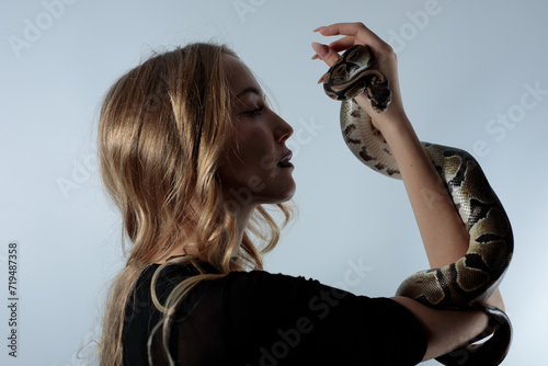 Snake python shooting on blond young woman with light effekts photo