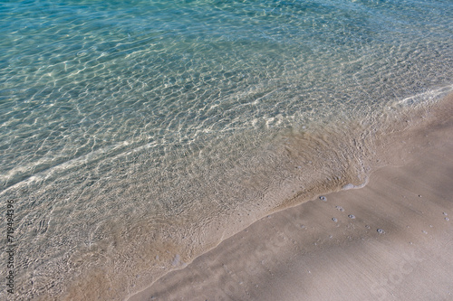 Clear water reflections on shallow sandy beach bottom. UAE Jumeirah beach.