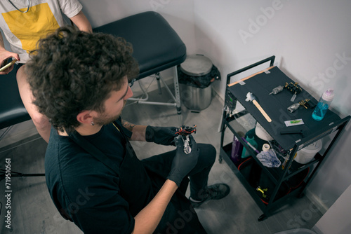 Male Tattoo Artist at Work in a Modern Tattoo Studio Preparing Equipment