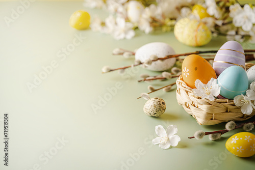 Spring Easter holiday green background with eggs in basket and spring flowers. Greeting card background with copy space.