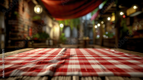 Classic red and white checkered tablecloth placed on sturdy wooden table. Perfect for adding touch of charm to any rustic or outdoor setting photo