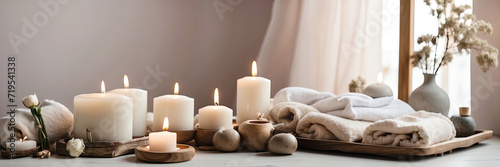 The interior of the massage room in eco-style and beige tones with natural fabrics and materials, Potted plants. Rolled towels on the massage table, candles, relaxing atmosphere