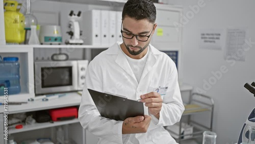 Wallpaper Mural A professional man examines documents in a laboratory setting, suggesting meticulous research or testing. Torontodigital.ca