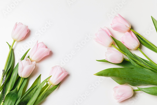 Fototapeta Naklejka Na Ścianę i Meble -  Light pink blooming tulips flowers over white background. Spring holiday banner, frame, border, happy easter card, mothers day, international womans day. Flat lay, top view, copy space