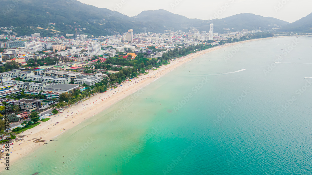 Aerial view, drone flying over Phuket city, Thailand. Drone over Patong Beach on Sunday in Phuket and tourists shopping at a street full of local merchants selling food, people resting by the sea.