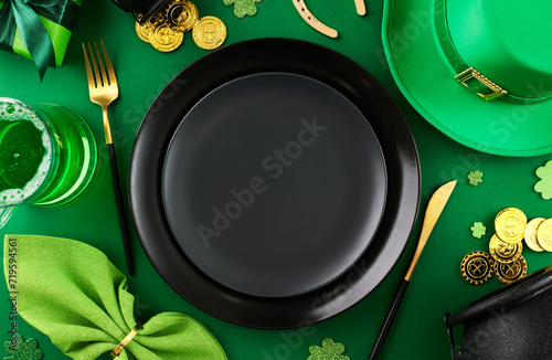 Clover brilliance: Celebratory setup for St. Patrick's Day. Top view photo of plates, cutlery, leprechaun hat, green beer, festive decor on green background photo