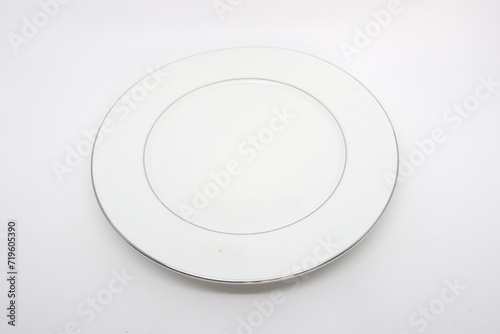 a plain white round plate made of glass on a white background