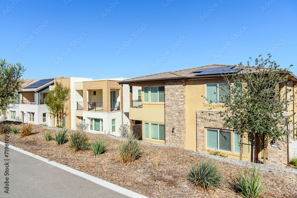 Fototapeta premium Row of new energy efficient semi detached houses with rooftop solar panels in a housing development on a clear autumn day