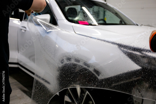 The process of installing PPF on a car. PPF is a protective film for paint that protects the paint from scratches and gravel.Anti-gravity protection. PFF is installed. Wrapping a car in close-up photo
