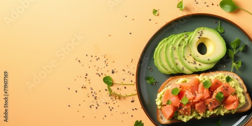 Healthy meal concept. Close up of breakfast plate from above scrambled eggs and avocado, a slice of bread, bacon isolated on yellow bakcground. photo