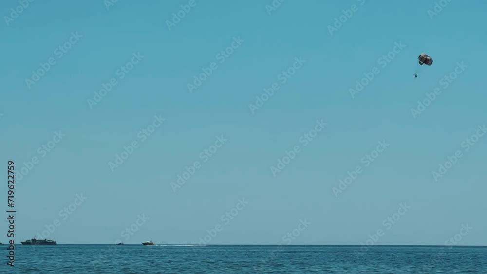 Parasailing: a boat with a marine parachute on the waves. The concept of a cloudy landscape, freedom and summer. Parachutists over the surface of the Black Sea against the sky on a summer day. 4K Parasailing: a boat with a marine parachute on the waves. The concept of a cloudy landscape, freedom and summer. Parachutists over the surface of the Black Sea against the sky on a summer day. 4K