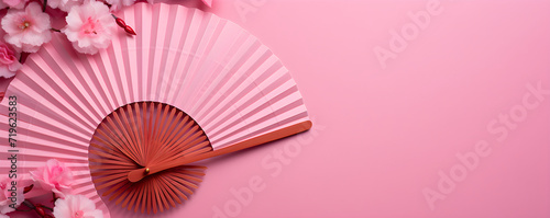 Festival paper fans and blossom flowers on pink background. Happy Chinese New Year. Spring floral banner in traditional japanese style