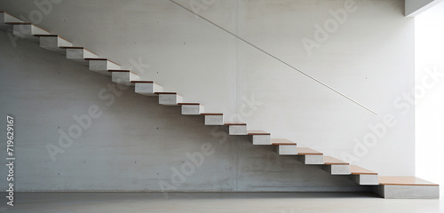 A minimalist staircase with thin concrete treads and a simple, yet elegant metal handrail. © hassan