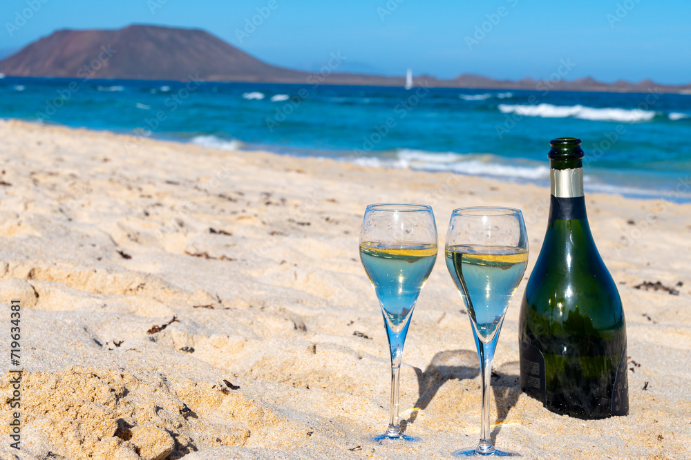 Pouring a glass of champagne on vacation, south of Fuerteventura, Canary islands, blue ocean, mountains Pouring a glass of champagne on vacation, south of Fuerteventura, Canary islands, blue ocean, mountains