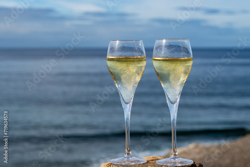 Pouring a glass of champagne on vacation, south of Fuerteventura, Canary islands, blue ocean, mountains