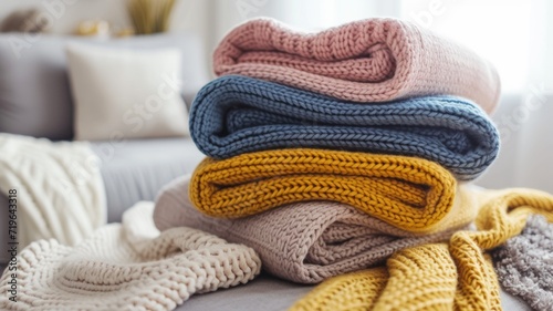 crocheted and knitted clothes of different colors stacked neatly in a bright living room