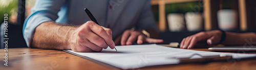 Person Writing on White Sheet of Paper With Blue Pen photo