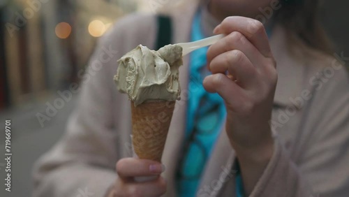 Close up of woman enjoys a delicious ice cream cone during spring vacation outdoors in Rome, Italy. 