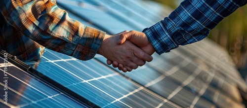 Smiling handyman photovoltaics panels installer shaking hand with family owner of house. Copy space image. Place for adding text