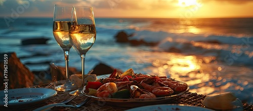 Romantic dinner at the beach restaurant overlooking the sunset on the ocean on a beautifully served table seafood and white wine. Copy space image. Place for adding text photo