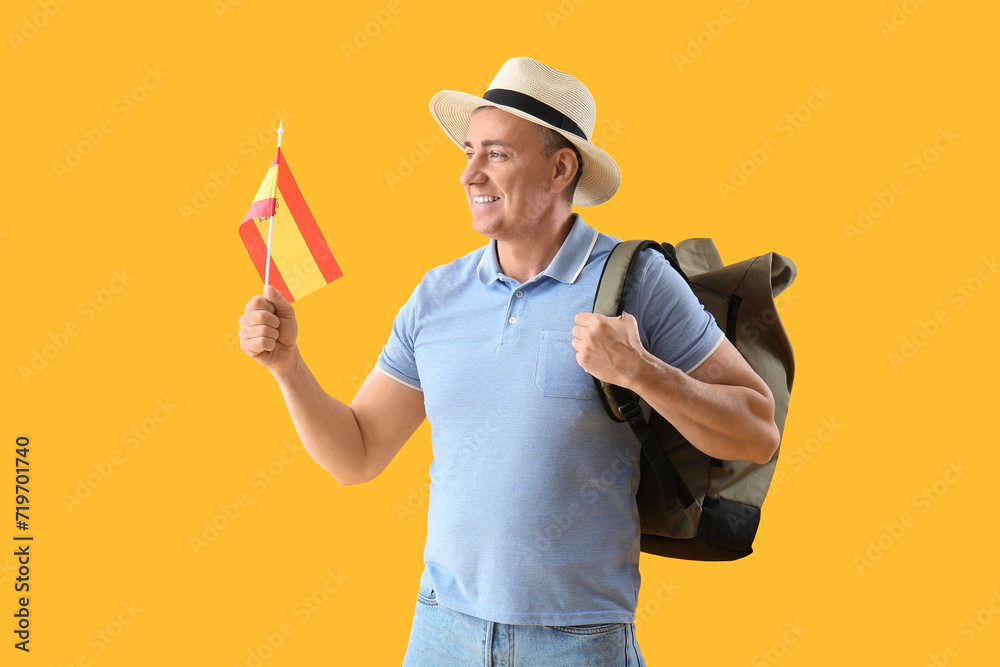 Mature tourist with flag of Spain on yellow background