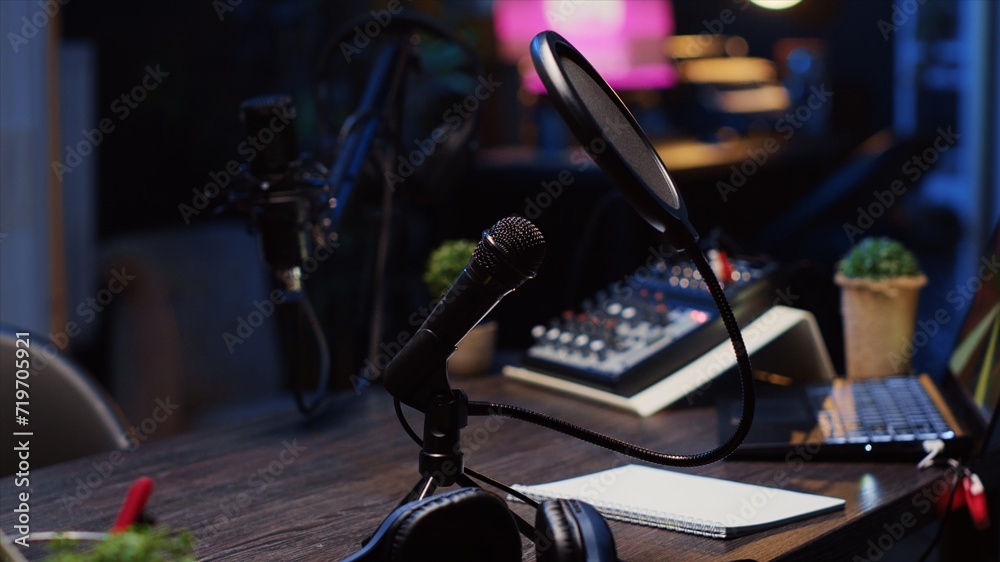 Close up shot of specialized radio microphone used in home personal studio by dj to record internet show guests. Professional audio devices in empty living room used for producing internet show Close up shot of specialized radio microphone used in home personal studio by dj to record internet show guests. Professional audio devices in empty living room used for producing internet show