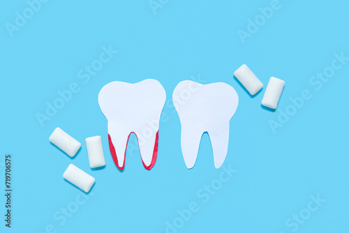 Paper teeth and white chewing gums on blue background