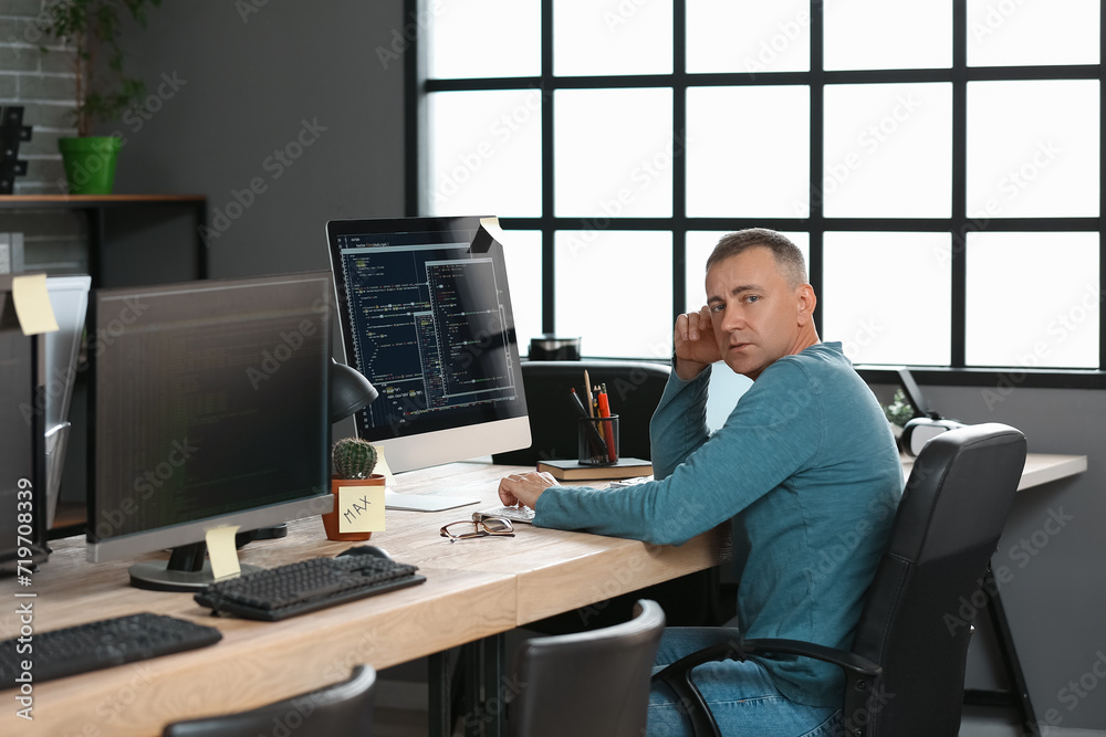 Mature male programmer working in office
