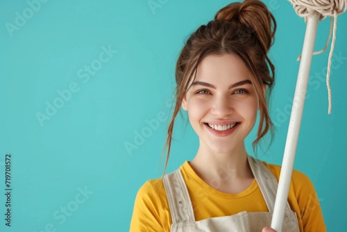 Smiling young woman with mop on blue background. Spring cleaning, home cleaning, housework and hygiene concept. Eco friendly and zero waste. Design for banner, poster with copy space