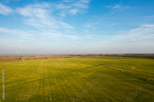 Skyward Horizons: Aerial View of Fields Beneath a Blue Sky