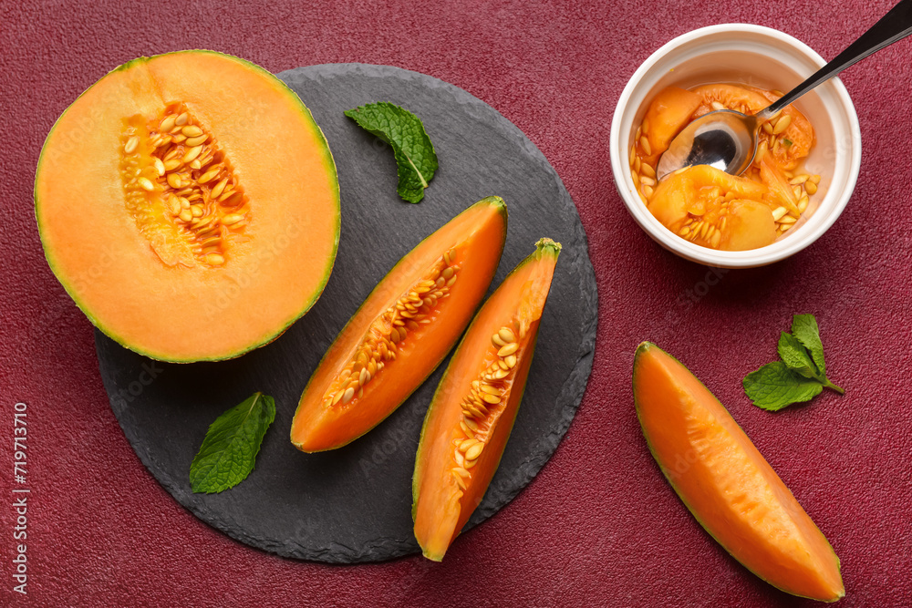 Slate board with tasty ripe melon on red background Slate board with tasty ripe melon on red background