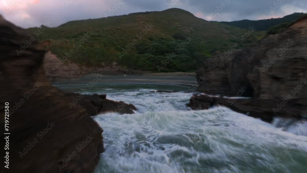 Aerial: Dreamy abstract waves crashing over rocks in in slow motion at sunset giving the feeling of heaven Aerial: Dreamy abstract waves crashing over rocks in in slow motion at sunset giving the feeling of heaven