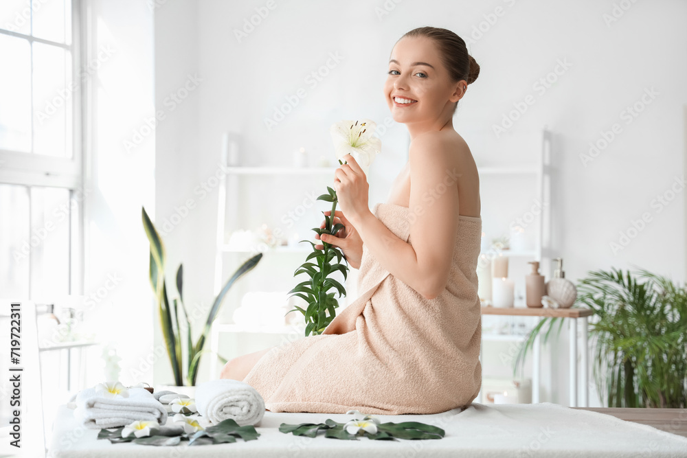 Beautiful young woman with flower in spa salon Beautiful young woman with flower in spa salon