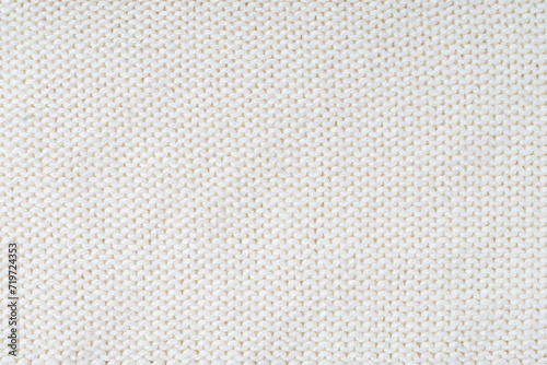 Close up background of knitted wool fabric made of viscose yarn, white color wool knitwear texture. Sweater, pullover knitted jersey background. Fabric abstract backdrop, wallpaper