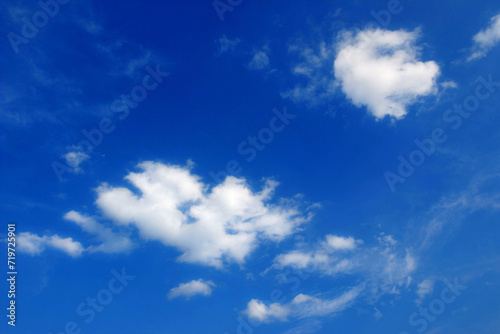 two white fair weather clouds  cumulus in the blue sky