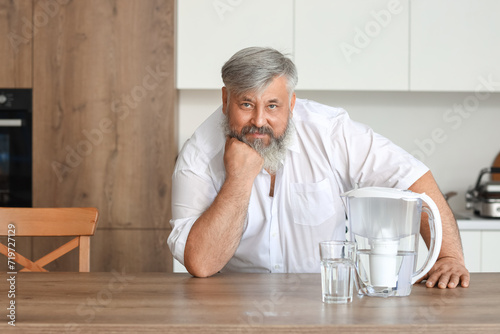 Mature man with filter jug ...
