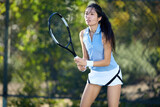 An asian girl plays tennis on a private court