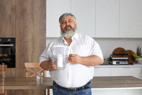 Mature man with filter jug ...