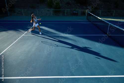 An asian girl plays tennis on a private court © joescarnici